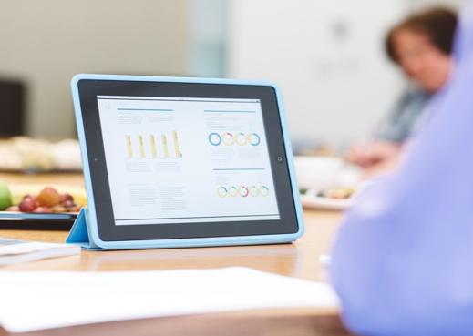 Man with tablet with graphs on table
